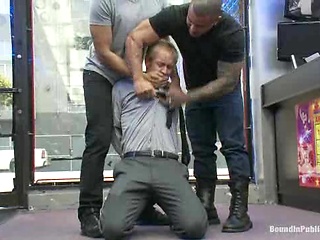 Two thugs drag a businessman into a porn shop and strip him of his manhood.